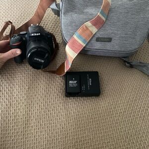 Nikon DSLR Camera in Black with Colorful Strap and Gray Carry Case